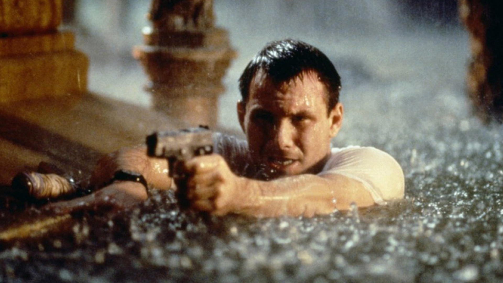 HARD RAIN: Christian Slater steht bis zu den Schultern im Wasser und richtet mit beiden Händen eine Pistole nach vorne.