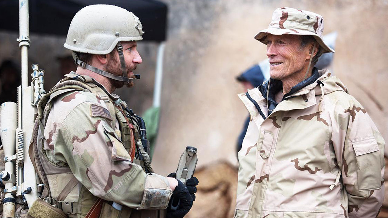Schauspieler als Regisseure: Bradley Cooper und Clint Eastwood unterhalten sich am Set von AMERICAN SNIPER. Beide tragen Tarnkleidung.