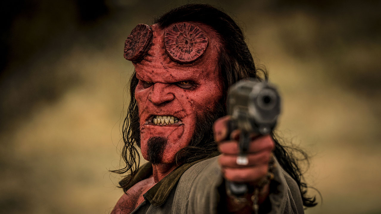HELLBOY – CALL OF DARKNESS: Hellboy (David Harbour) richtet frontal eine Pistole auf den Zuschauer und schaut grimmig.