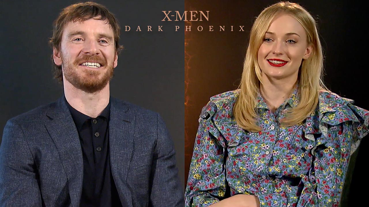 X-MEN: DARK PHOENIX: Die linke Bildhälfte zeigt Michael Fassbender, die rechte Sophie Turner in der Interview-Situation. Beide Darsteller lachen.